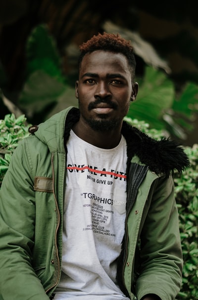 Green plant near a man dressed in a green zipper jacket
